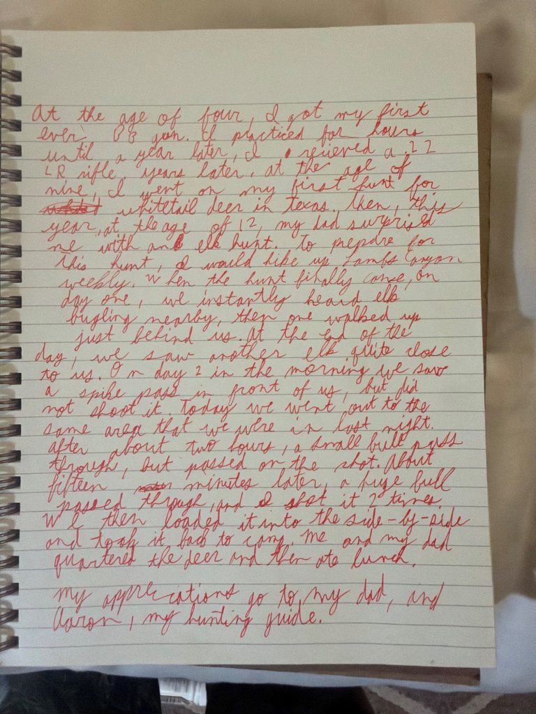 Handwritten story in cursive on lined notebook paper recounting a young person's first elk hunting trip with their dad and guide.