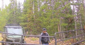 Stealth Cam security photo of UTV and person at ranch gate.